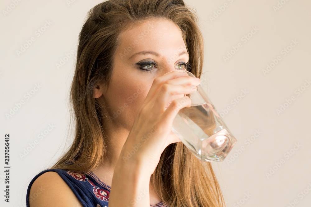 portrait of young woman drinking a glass of water portrait of young woman drinking a glass of water