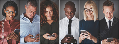 Smiling group of diverse businesspeople sending text messages photo