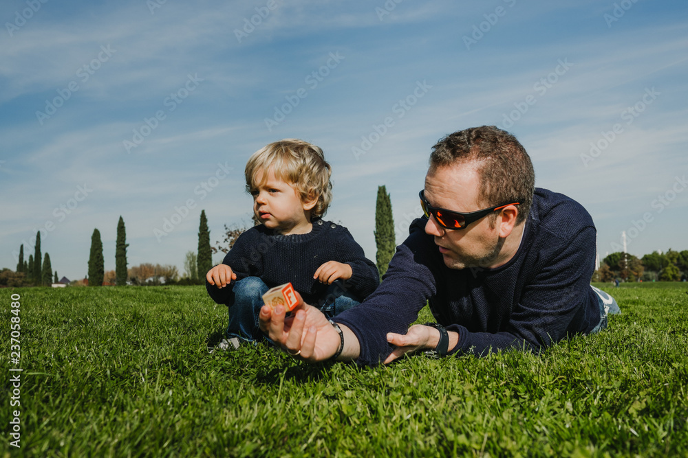 .Father and son playing on the grass a nice autumn morning. Sharing happy moments together. Lifestyle. .Father and son playing on the grass a nice autumn morning. Sharing happy moments together. Lifestyle.