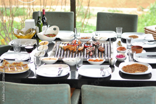 Traditional Cypriot meze and mix meat and chicken kebab table with charcoal barbecue on the table for self cooking during the eating time