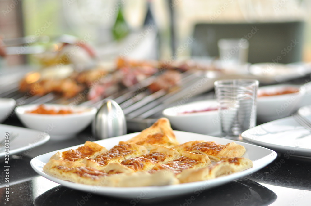 Traditional Cypriot meze and mix meat and chicken kebab table with charcoal barbecue on the table for self cooking during the eating time Traditional Cypriot meze and mix meat and chicken kebab table with charcoal barbecue on the table for self cooking during the eating time
