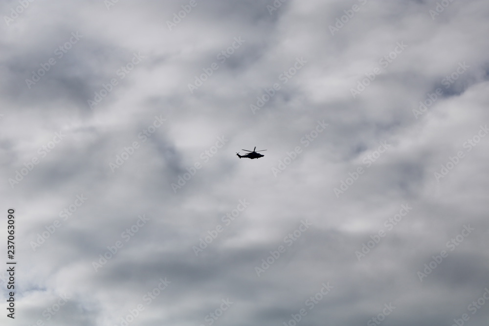 Silhouette di elicottero in volo con cielo nuvoloso