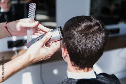 Close-up, master hairdresser does hairstyle and style with scissors and comb. Concept Barbershop
