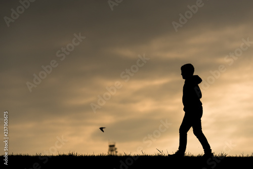 silhouette of a child on a dike