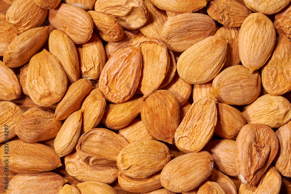 Scattered almond nuts on a brown background. Selective focus Scattered almond nuts on a brown background. Selective focus