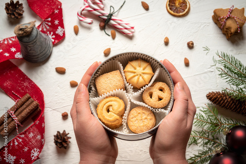 Фотография Woman holding cookies box above christmassy table