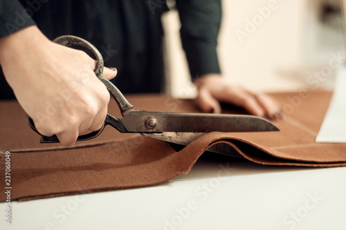 Tailor at work, drawing line on fabric with chalk photo