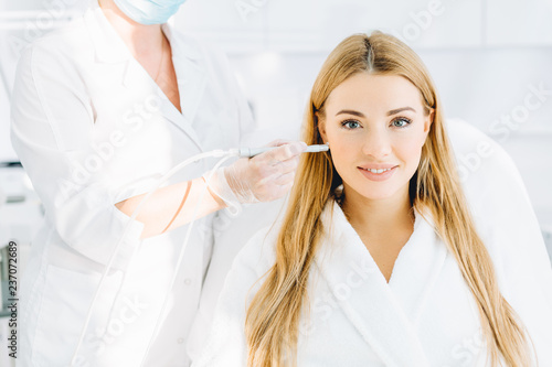 Young blonde female beauty getting effective removal treatment on her skin  such as dermabrasion  gas-liquid peeling during a visit in beauty salon