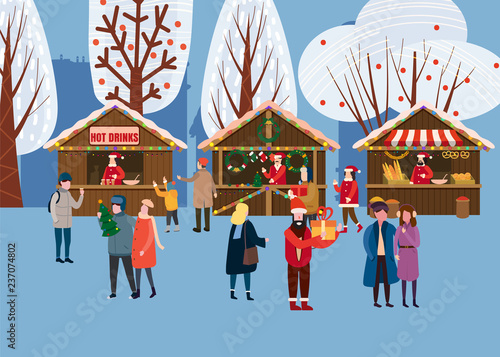 Christmas market or holiday outdoor fair on town square. People walking between decorated stalls, canopy or kiosks, buying snacks,gifts, decoration and drinking hot coffe, tea and mulled wine