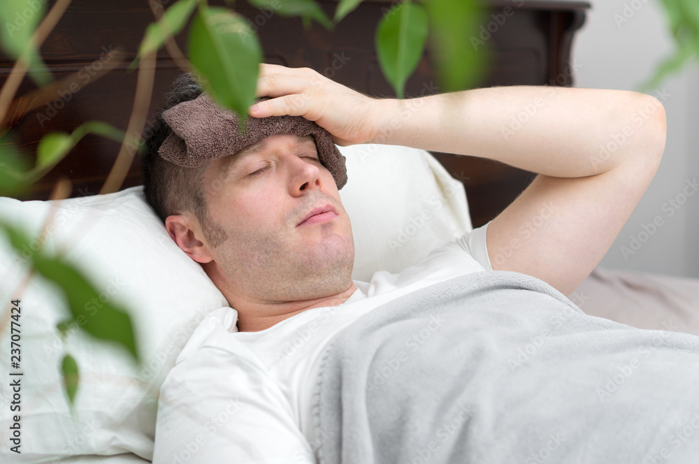 Sick man with fever lying in the bed. Sick man with fever lying in the bed.