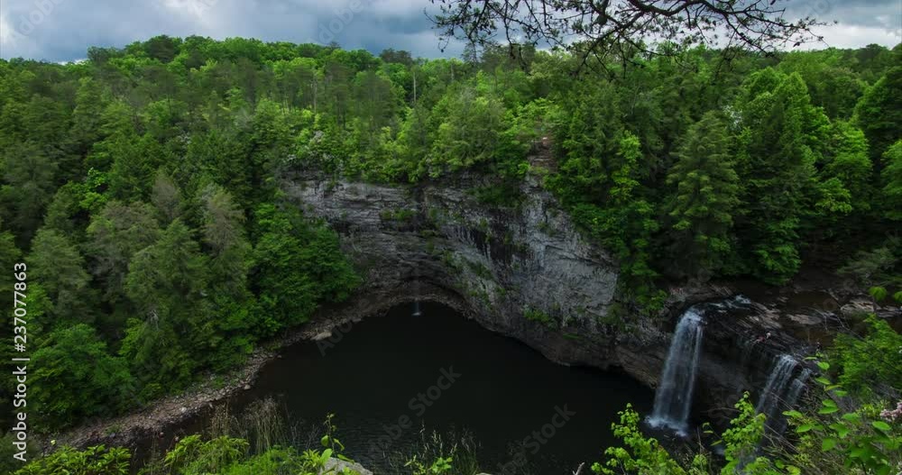 Waterfall cliff with heavy clouds and trees Waterfall cliff with heavy clouds and trees