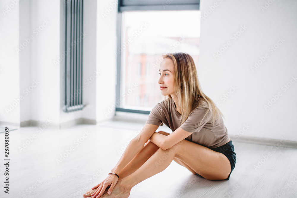 Beautiful cheerful young woman sitting on the floor in the room. close up photo. free time, lifestyle Beautiful cheerful young woman sitting on the floor in the room. close up photo. free time, lifestyle
