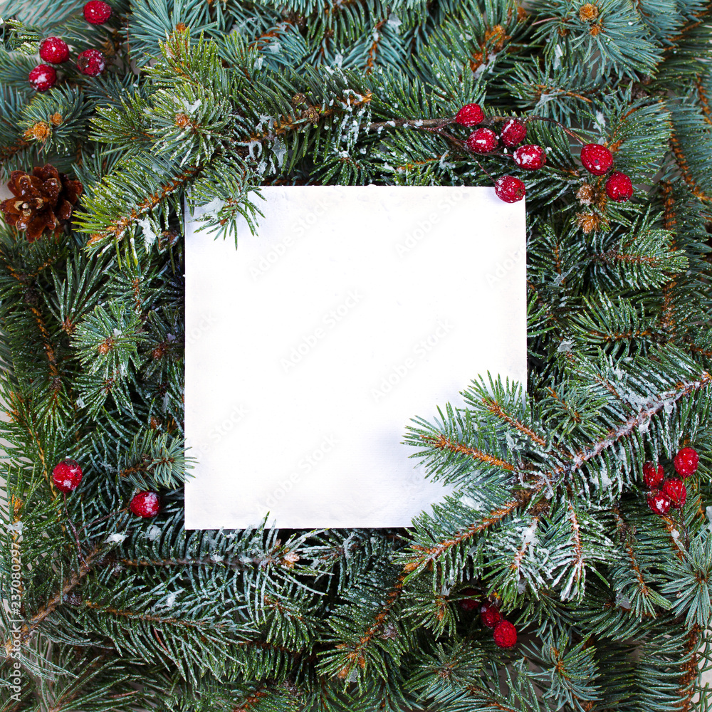 Layout made of Christmas tree branches, red berries and paper card note. Mockup, flat lay. New Year winter season concept Layout made of Christmas tree branches, red berries and paper card note. Mockup, flat lay. New Year winter season concept
