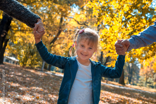 Portrait of beautiful smiling girl spending time with grandparents in autumn park
