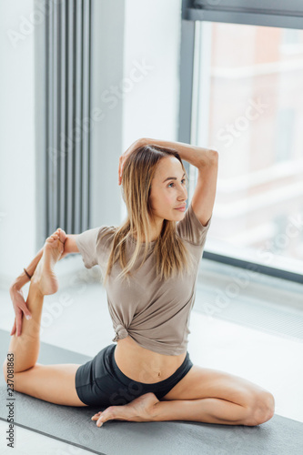 young sportswoman sitting on mermaid posture. full length side view shot.