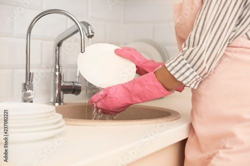 Fototapeta Naklejka Na Ścianę i Meble -  Woman doing washing up in kitchen sink, closeup view. Cleaning chores