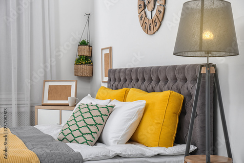 Big bed with soft pillows in stylish room interior photo