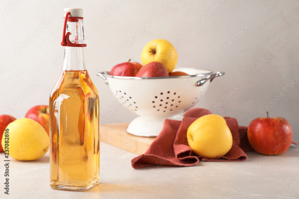 Composition with bottle of apple vinegar on table. Space for text Composition with bottle of apple vinegar on table. Space for text