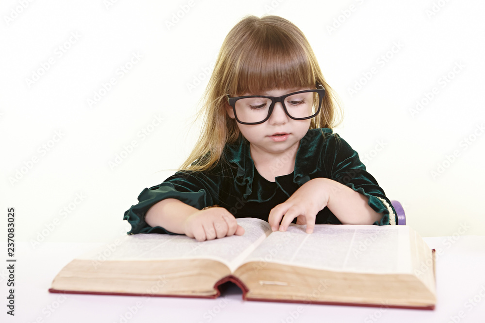 Girl child in glasses reads a book draws writes smiling Girl child in glasses reads a book draws writes smiling
