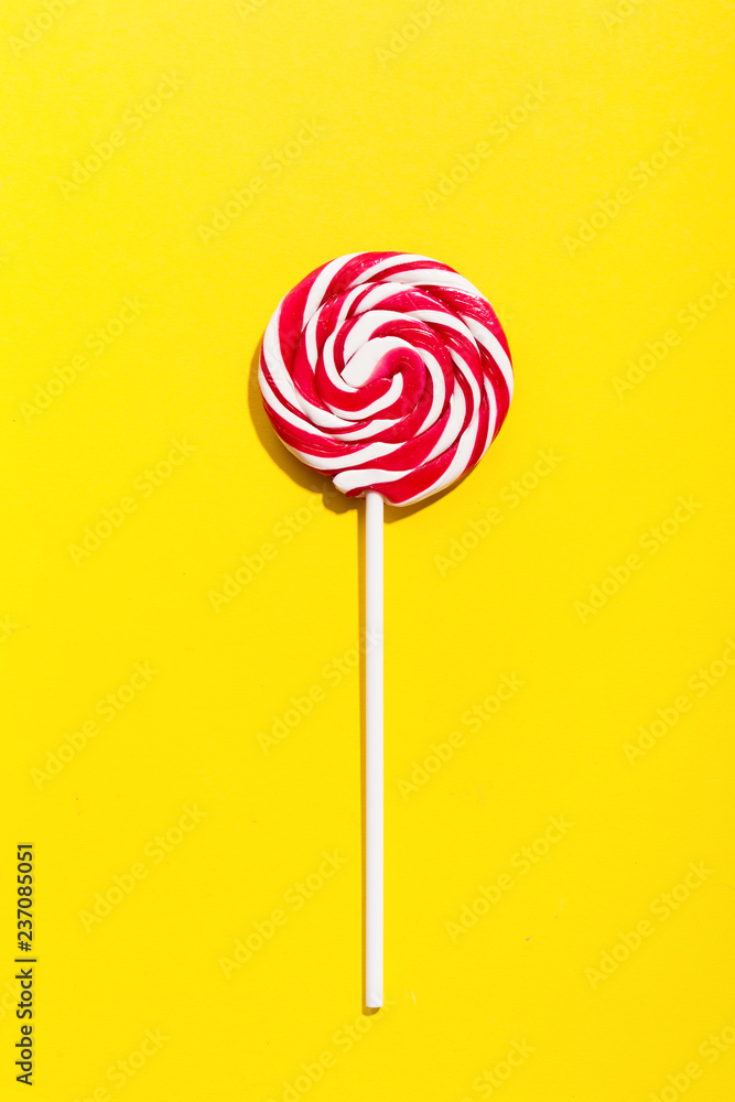 Red lollypop on yellow background Red lollypop on yellow background