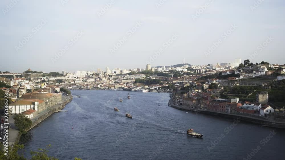 View above Douro river. Old european city on both banks and floating boats in sunny day. Porto, Portugal View above Douro river. Old european city on both banks and floating boats in sunny day. Porto, Portugal