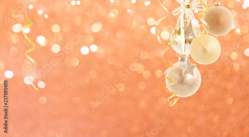 Hanging golden christmas balls with riboons on bright pink bokeh background photo
