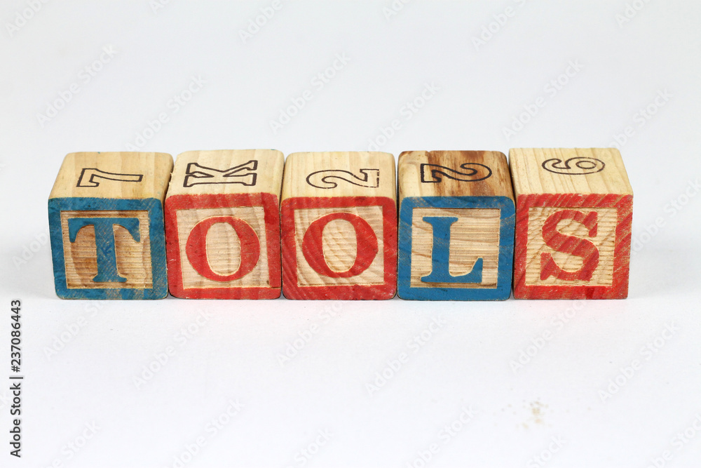 Wooden alphabet blocks spelling out TOOLS on white background. Colorfull wooden alphabet blocks. Wooden alphabet blocks spelling out TOOLS on white background. Colorfull wooden alphabet blocks.