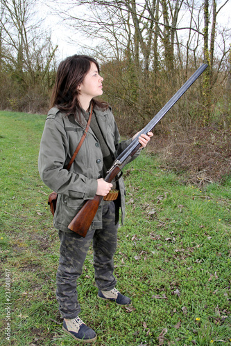 Proud woman hunter holding her vintage shotgun in the field