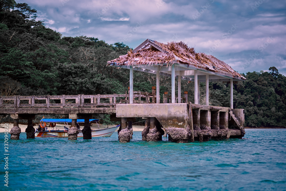 Obraz premium Tropical lagoon pier with a lonely boat. View of the Bay with a pier and a lonely boat.