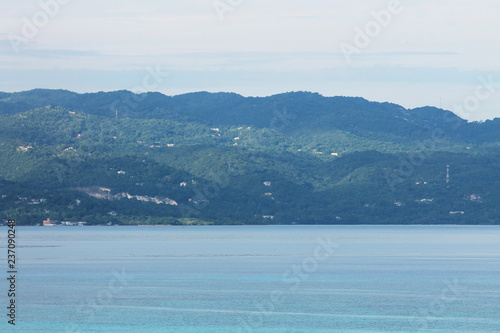Looking across the bay at the hills, and the hillside house nestled among the trees, Montego Bay, Jamaica.