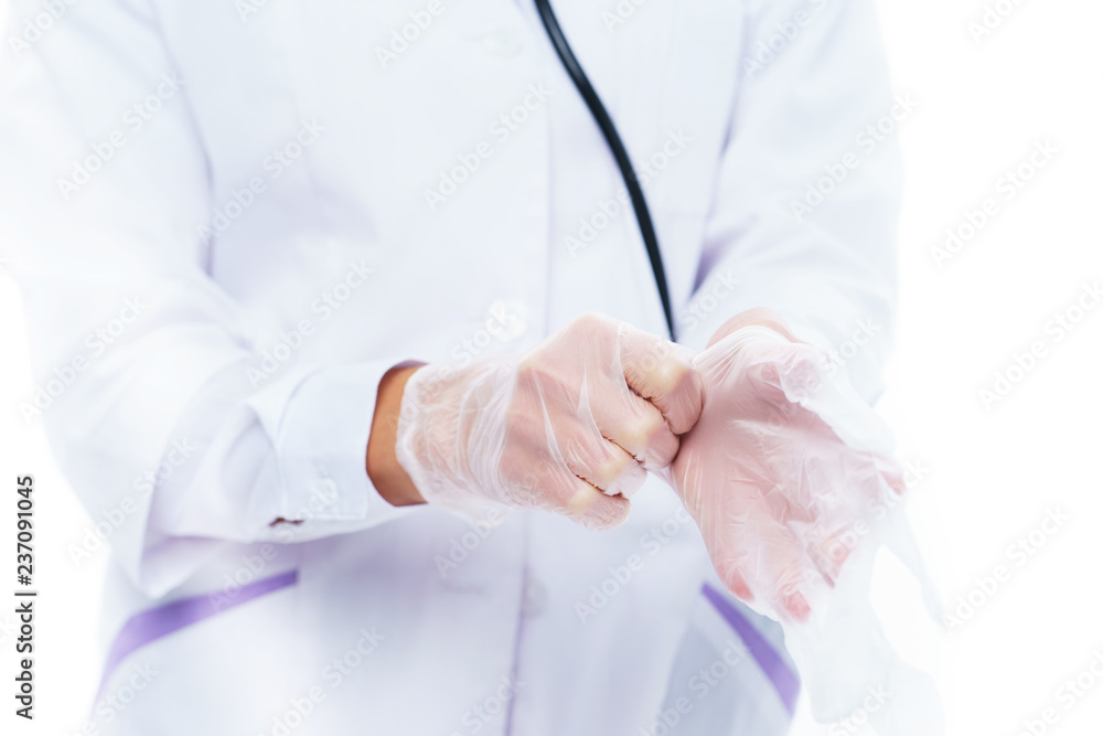 Medical professional, doctor or nurse puts white latex gloves on her hands before being examined, operated on or treated against a white background. Medical professional, doctor or nurse puts white latex gloves on her hands before being examined, operated on or treated against a white background.