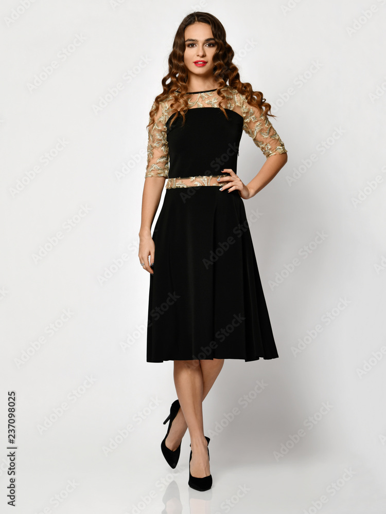 Young beautiful woman posing in new black fashion winter dress full body on a white Young beautiful woman posing in new black fashion winter dress full body on a white
