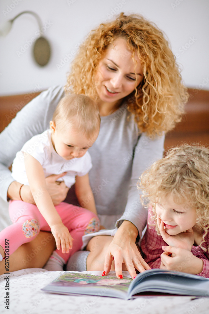 young beautiful mother teaching to love books. close up crooped photo. little bookwormes young beautiful mother teaching to love books. close up crooped photo. little bookwormes
