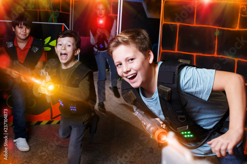 boy aiming laser gun at other players during lasertag game