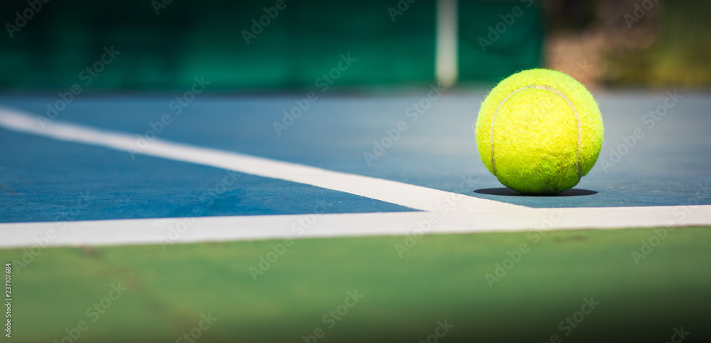 Tennis balls in court on corner blue floor in panorama