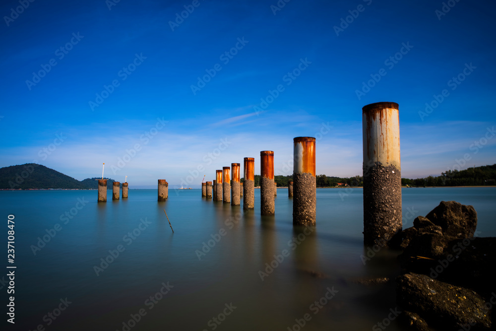 Abandon Piling Pier at Lumut,Malaysia With Smooth Water. Soft Focus,Blur Due To Long Exposure. Visible Noise Due To High ISO.