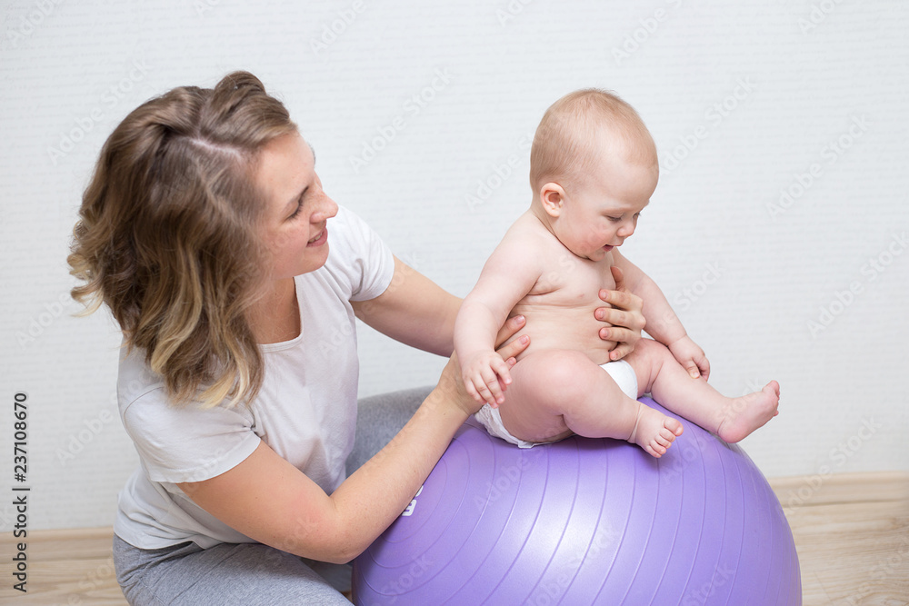 mother and her baby doing exercises on a ball mother and her baby doing exercises on a ball
