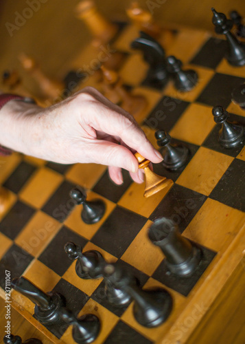 close-up view of a hand of elderly woman playing chess.