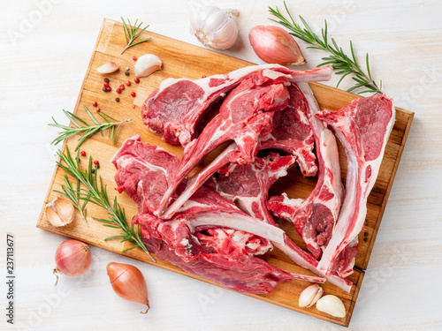 Raw lamb ribs on wooden chopping Board on white background, top view