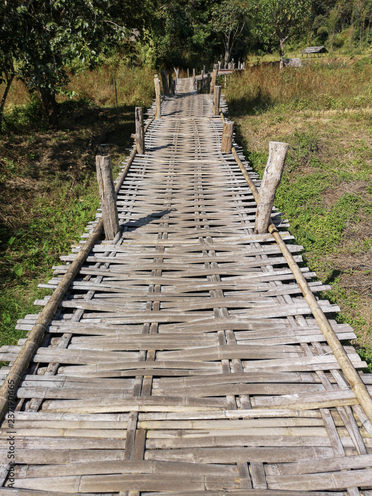 Romantic bamboo bridge crossing fields and nature, Northern Thailand landscape
