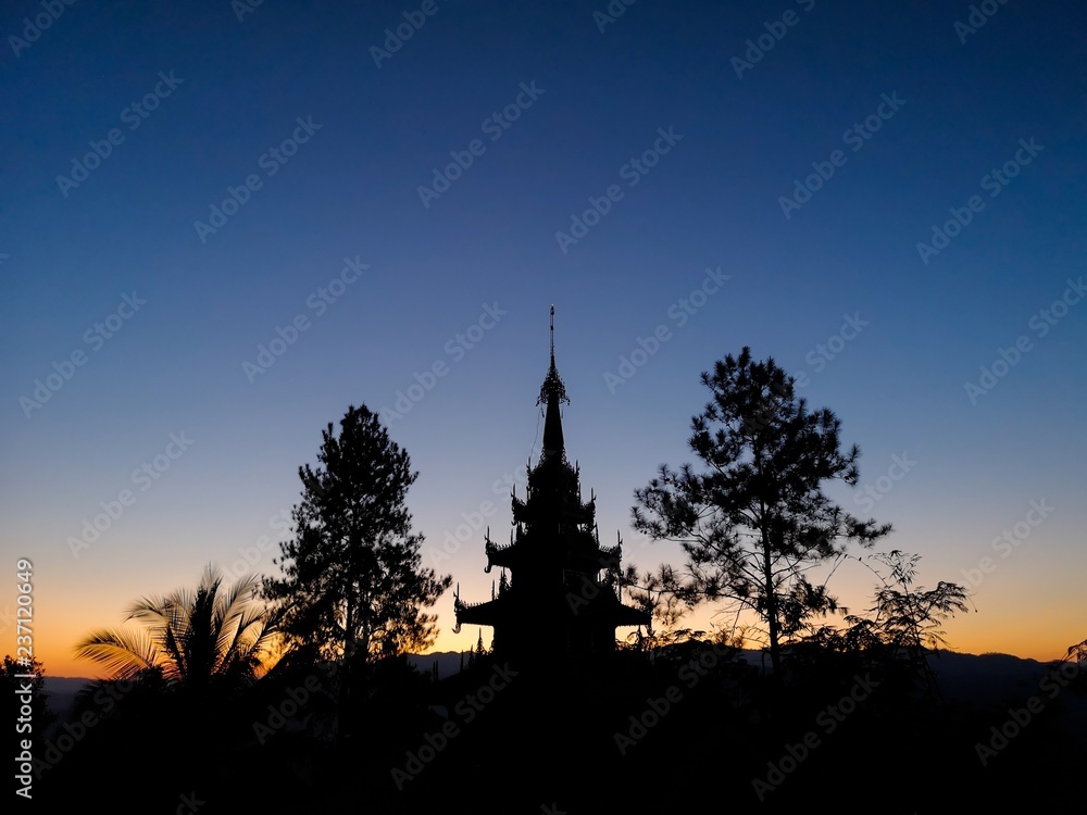 Buddhist pagoda silhouette with trees at sunset Buddhist pagoda silhouette with trees at sunset