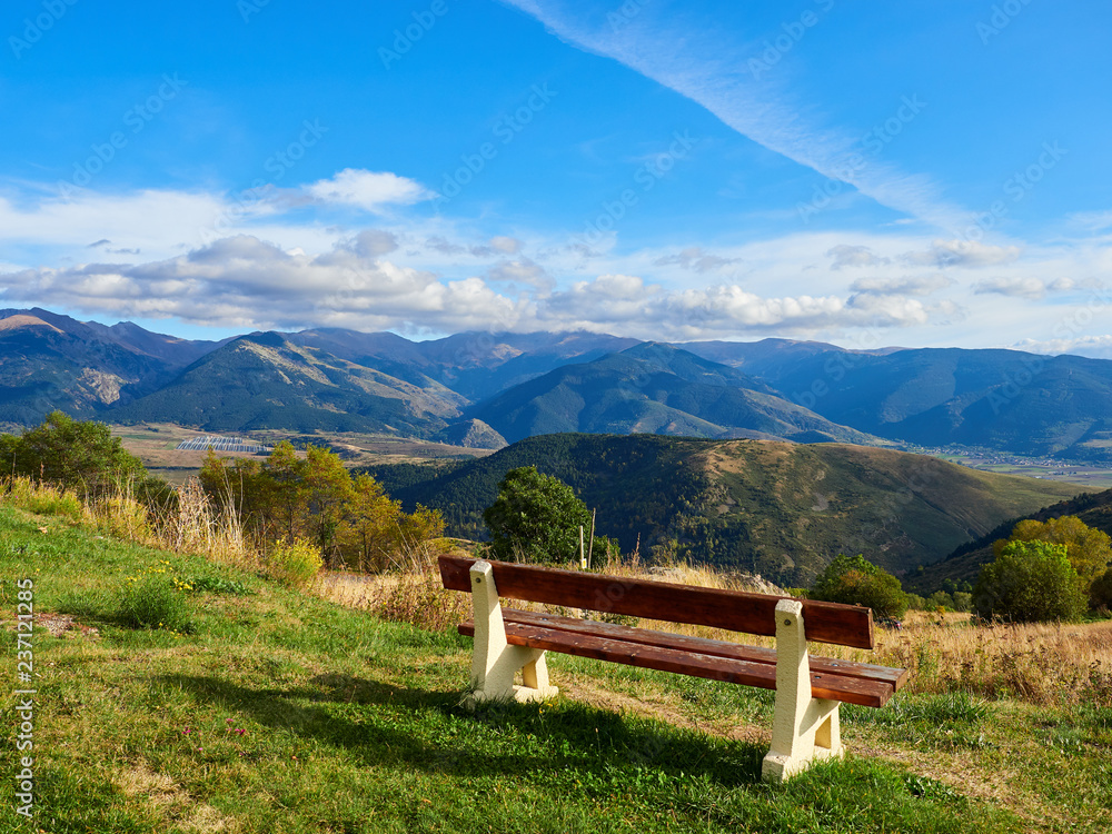 Wooden bench sitting at the top of a mountain on a sunny day, Font-Romeu, France