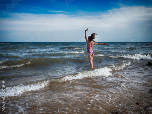 A teenage girl in a bathing suit, swims in the sea. photo