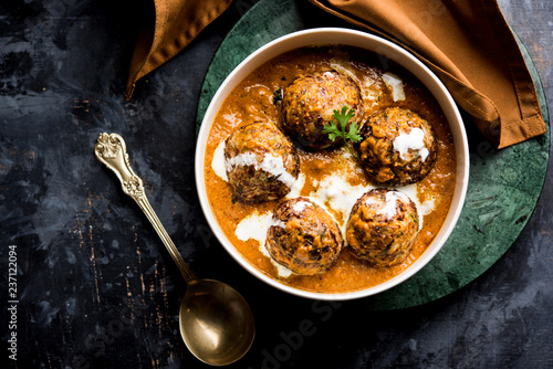 Malai Kofta is a Mughlai Speciality dish served in a bowl or pan over moody background. selective focus photo