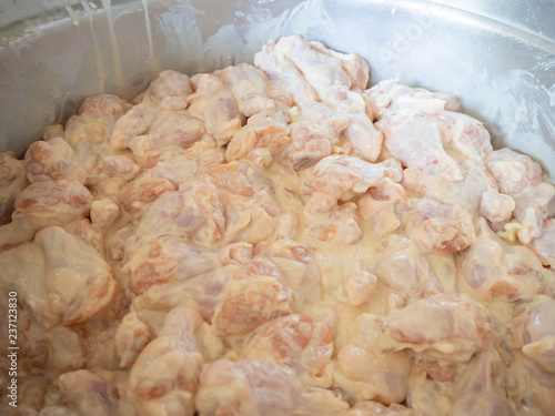 Raw chicken leg with all purpose flour in dish. photo