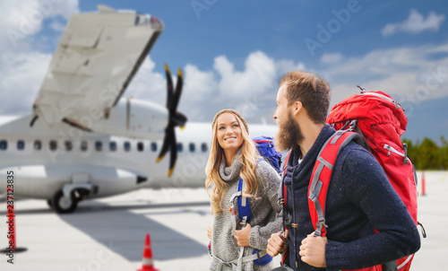 Slika na platnu travel, tourism and people concept - couple of tourists with backpacks over plan