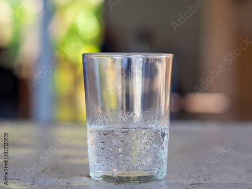 A glass of cold water on blurred background.