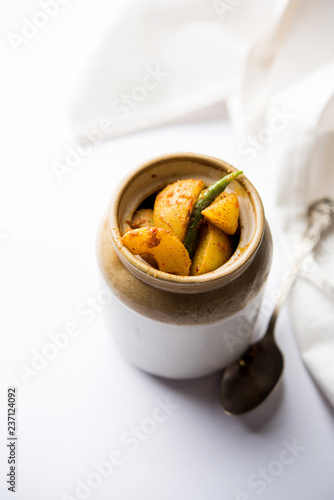 Homemade Gooseberry or amla Pickle/ or Aavle ka Achar in a bowl or barni over moody background. selective focus