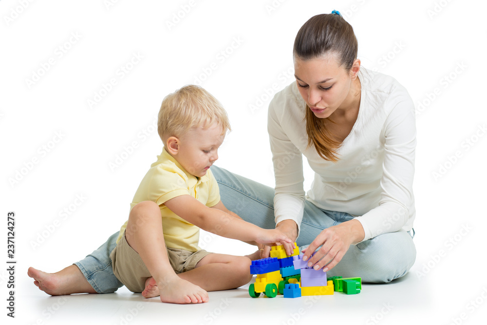 Mother and kid build out of colorful plastic blocks. Family and childhood concept. Mother and kid build out of colorful plastic blocks. Family and childhood concept.