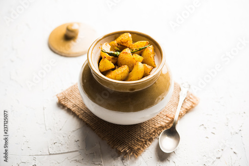 Homemade Gooseberry or amla Pickle/ or Aavle ka Achar in a bowl or barni over moody background.  selective focus photo